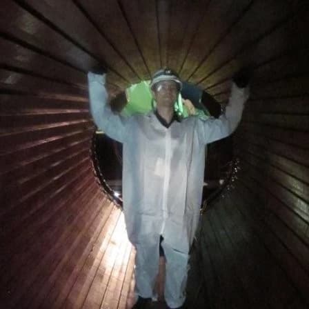 Fullpose of Matthew Pennington in a turbine generator, with rotor removed